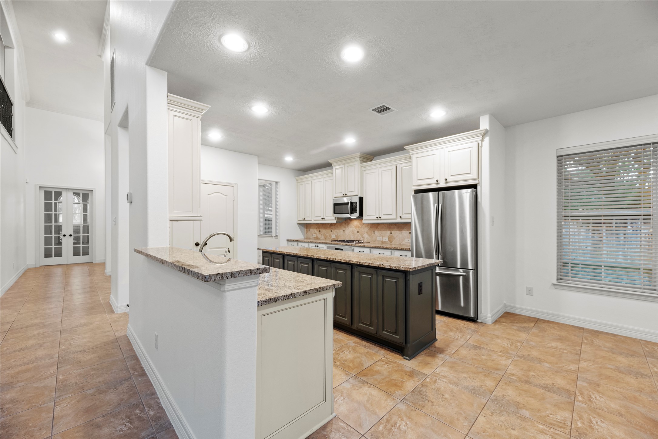 5827 Amherst Farms Lane Fulshear, TX 77441 - Photo 11 of 48 The spacious kitchen features granite countertops, abundant cabinetry with crown molding, and a large center island with contrasting darker cabinetry for visual interest. Stainless steel appliances, recessed lighting, and a generous breakfast bar create a highly functional and stylish space for everyday living and entertaining.