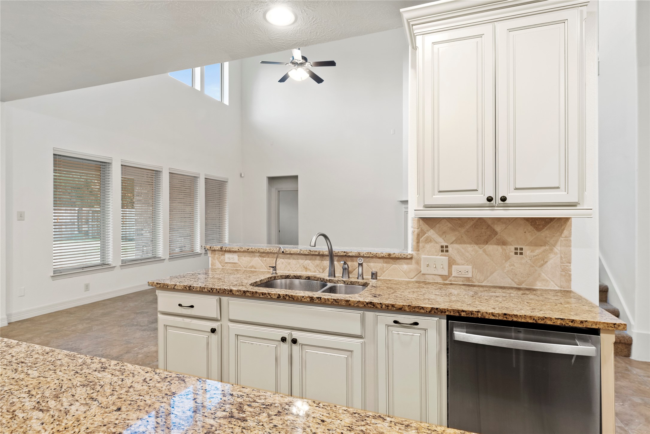 5827 Amherst Farms Lane Fulshear, TX 77441 - Photo 14 of 48 This angle showcases the deep double-basin sink, granite surfaces, and breakfast bar overlooking the two-story living room. The open sightlines allow you to enjoy views of the fireplace and natural light-filled windows while preparing meals or hosting guests.