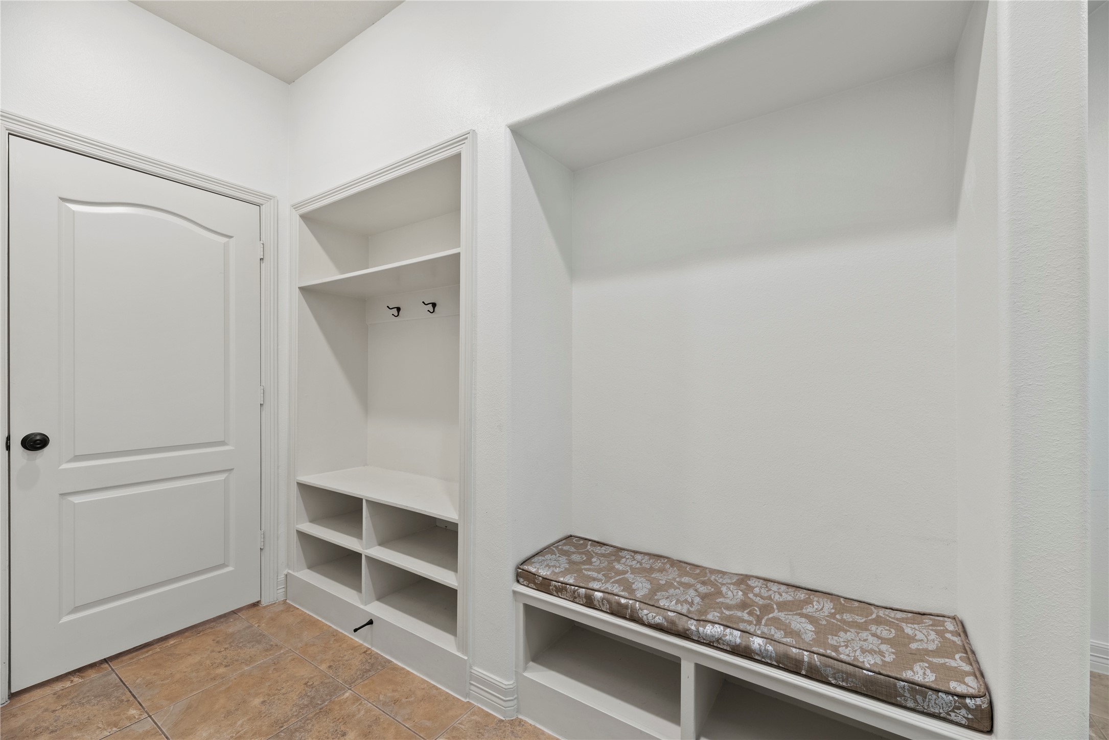 5827 Amherst Farms Lane Fulshear, TX 77441 - Photo 22 of 48 This thoughtfully designed mudroom area offers built-in shelving, cubbies, and coat hooks for everyday organization. A built-in bench with a cushioned seat provides a comfortable place to sit while removing shoes.