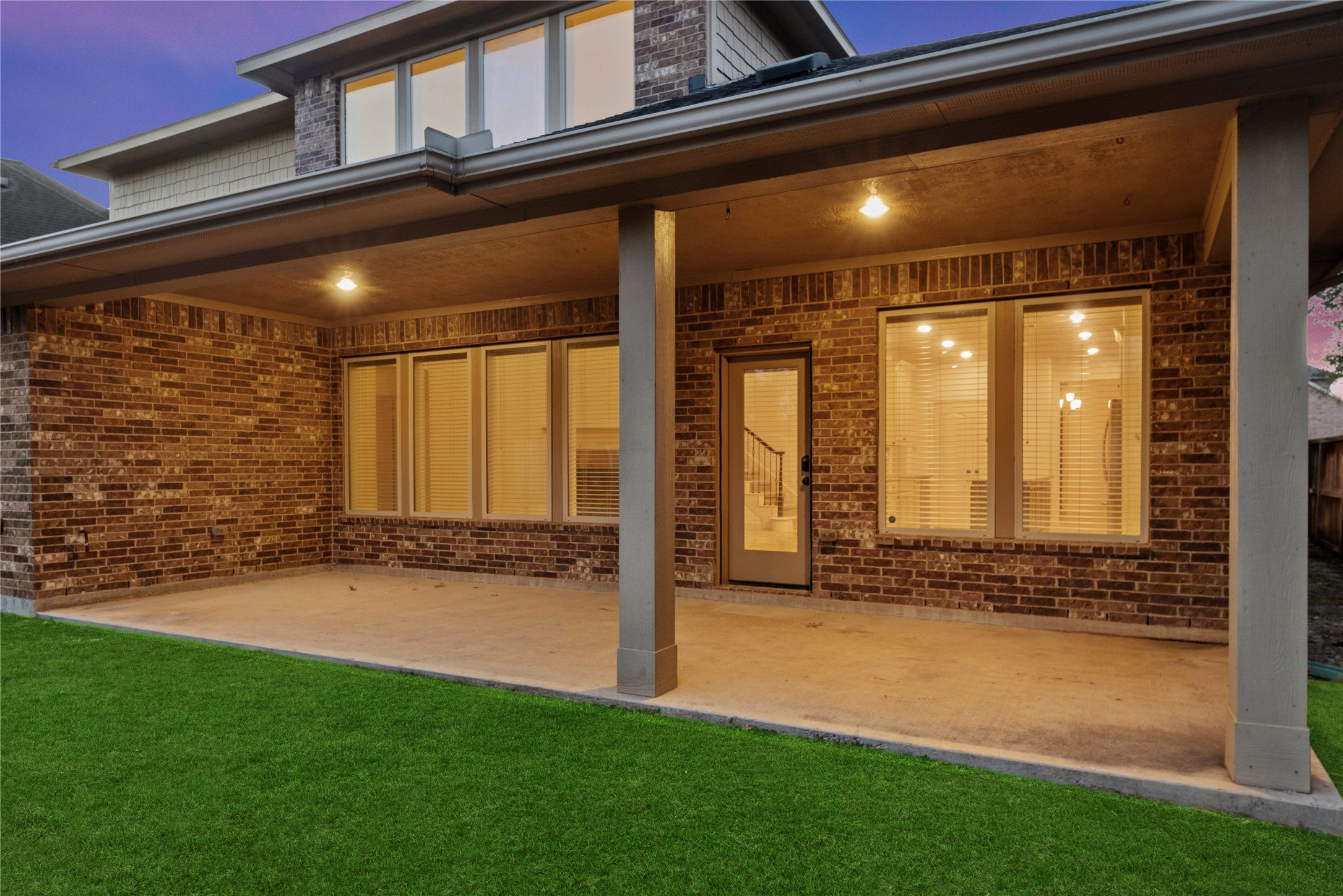 5827 Amherst Farms Lane Fulshear, TX 77441 - Photo 33 of 48 A closer perspective highlights the spacious covered patio with recessed lighting and sturdy support columns. The concrete slab provides ample room for outdoor dining, lounge seating, or a future outdoor kitchen setup.