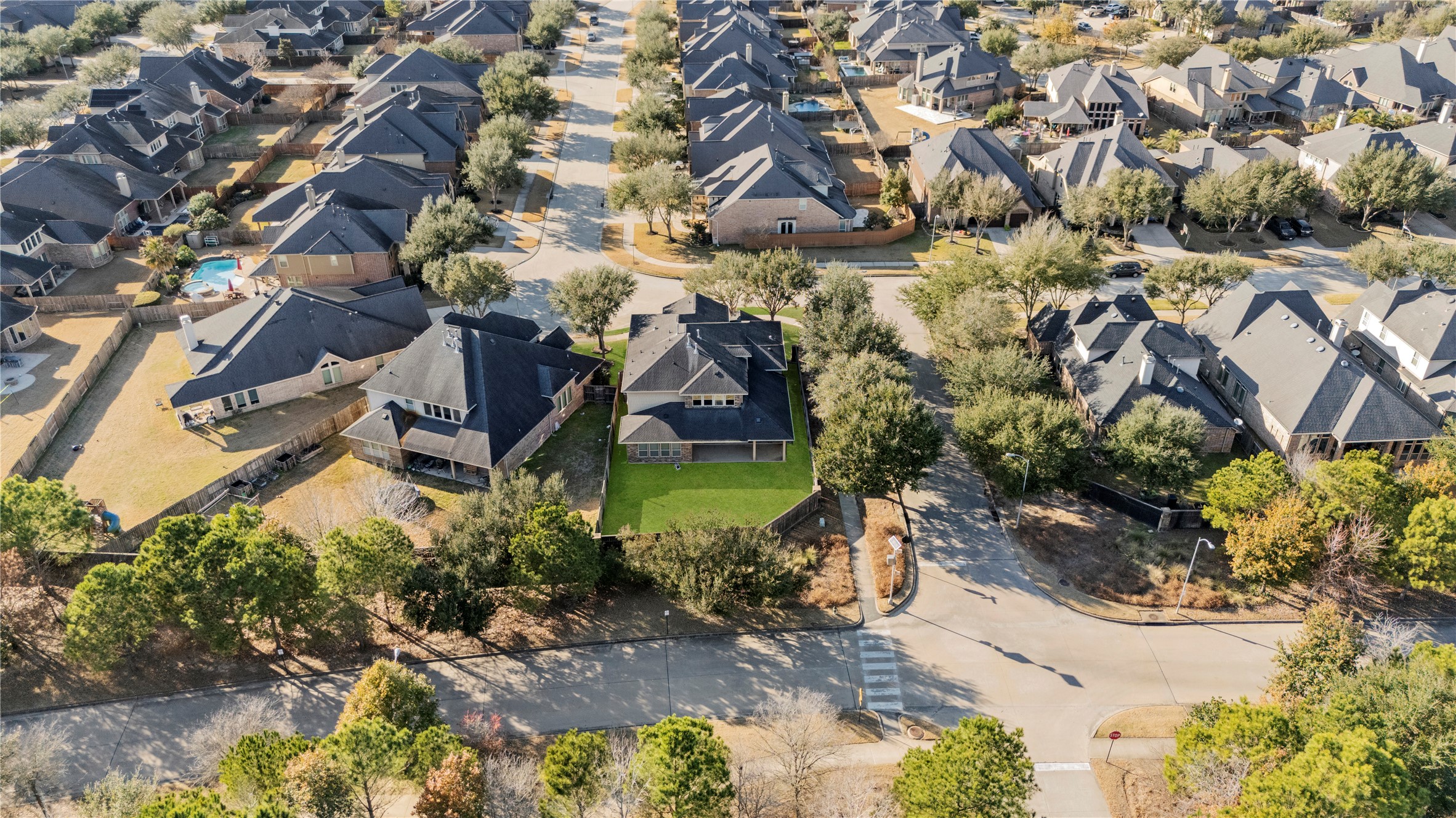 5827 Amherst Farms Lane Fulshear, TX 77441 - Photo 40 of 48 Aerial perspective showcases the home’s prime corner location within a quiet cul-de-sac. Surrounded by mature trees and well-maintained neighboring properties, the residence offers added privacy with greenbelt space just beyond the backyard.