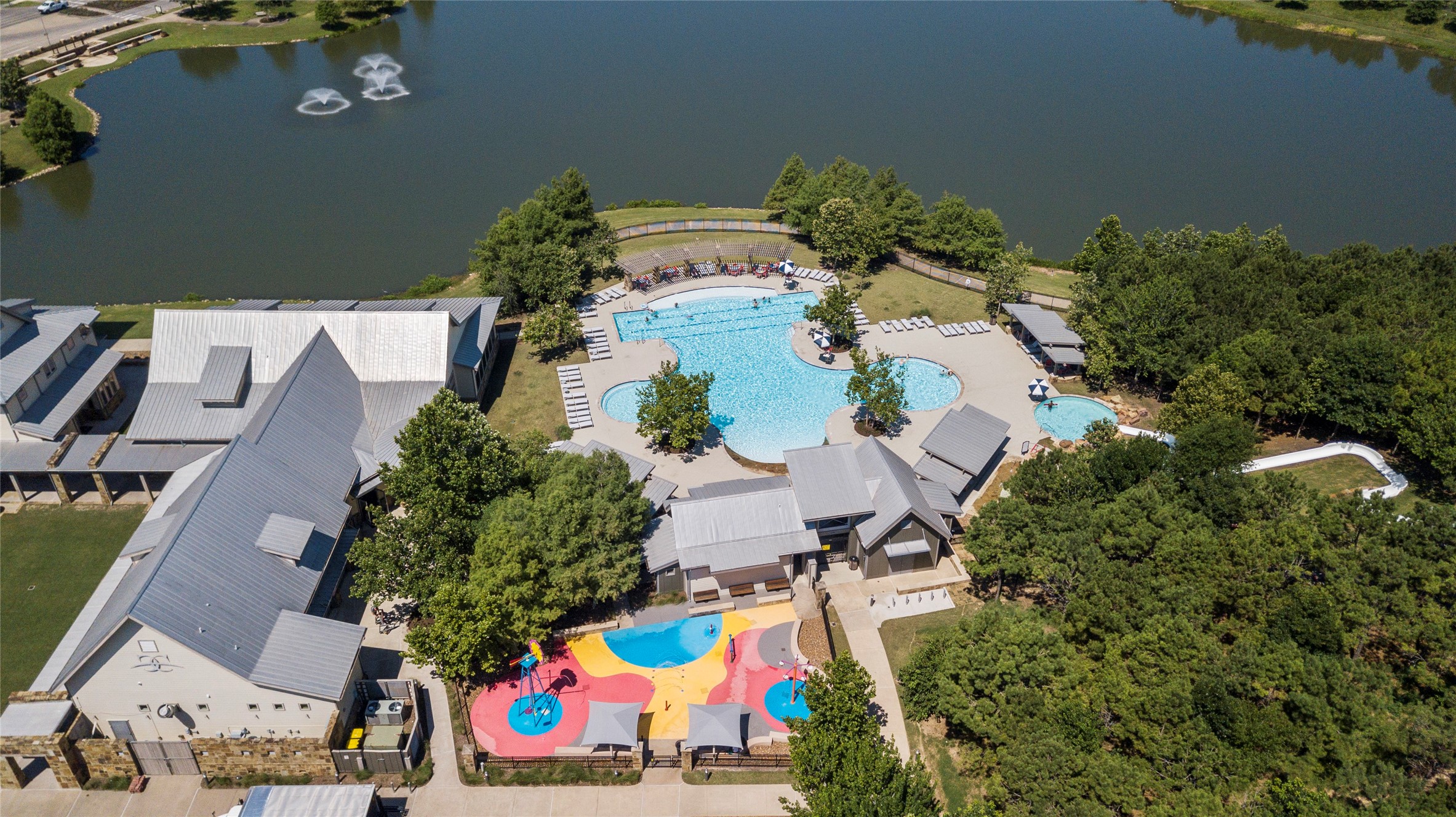 5827 Amherst Farms Lane Fulshear, TX 77441 - Photo 43 of 48 The Ranch House courtyard features manicured green space framed by rustic stone and metal architecture. A distinctive art installation anchors the lawn, creating a welcoming place for community events, social gatherings, and neighborhood activities.