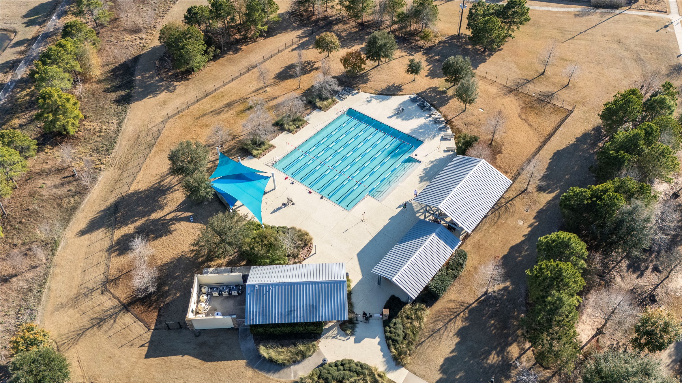 5827 Amherst Farms Lane Fulshear, TX 77441 - Photo 44 of 48 An aerial view of the community lap pool reveals dedicated swim lanes, shaded structures, and surrounding lounge areas. The thoughtfully designed aquatic center offers residents a refreshing retreat for exercise and relaxation alike.