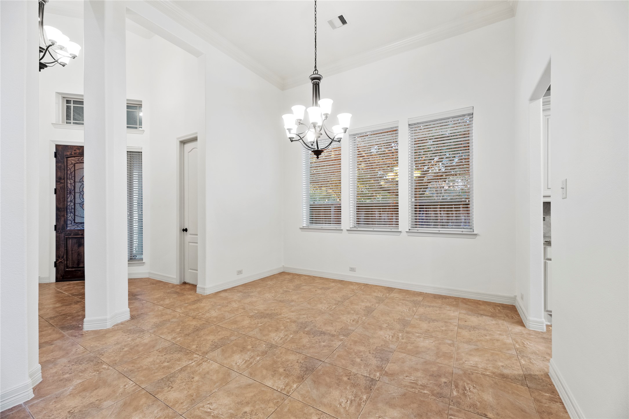 5827 Amherst Farms Lane Fulshear, TX 77441 - Photo 6 of 48 The formal dining room is generously sized & positioned just off the entry. A statement chandelier anchors the space, while large windows provide natural light and outdoor views. Crown molding and tall ceilings add elegance, and the open layout allows for easy flow to the kitchen, making entertaining effortless.