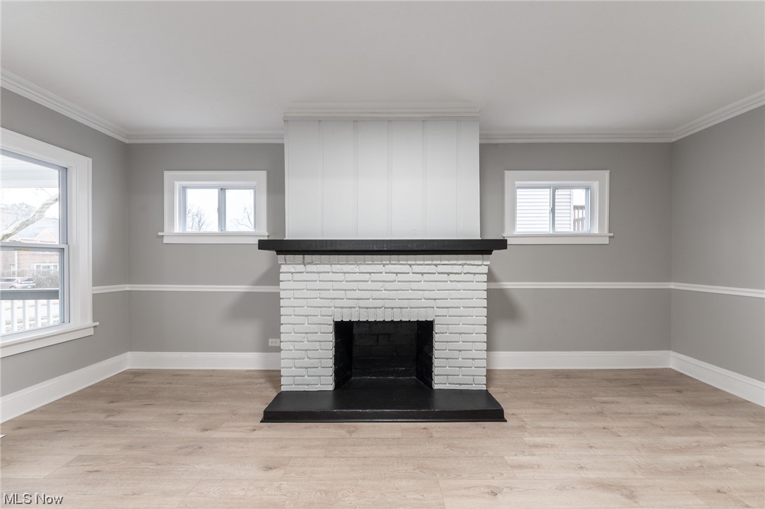 3517 Bainbridge Road Cleveland Heights, OH 44118 - Photo 7 of 35 Unfurnished living room with a wealth of natural light, light hardwood / wood-style floors, a fireplace, and ornamental molding