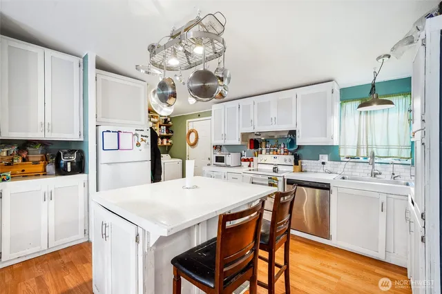 a kitchen with a stove a table and chairs in it