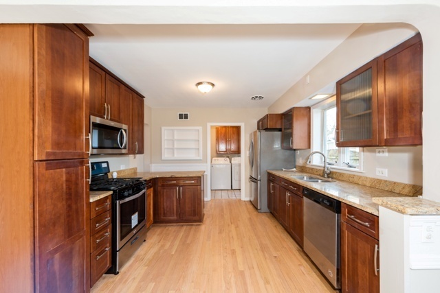 1111 Webster Lane Des Plaines, IL 60016 - Photo 2 of 25 a large kitchen with stainless steel appliances granite countertop a stove top oven a sink dishwasher a refrigerator and cabinets with wooden floor