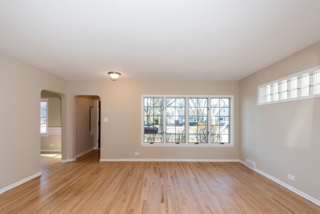 1111 Webster Lane Des Plaines, IL 60016 - Photo 6 of 25 an empty room with wooden floor and windows