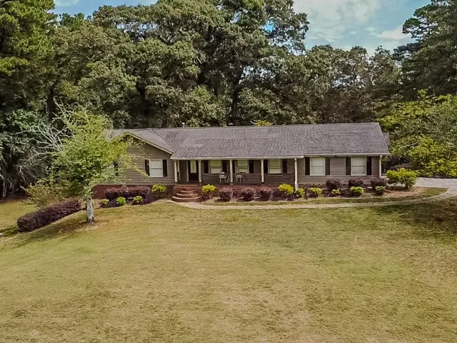 a front view of a house with swimming pool having outdoor seating