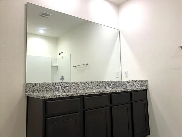 a bathroom with a granite countertop sink and a mirror