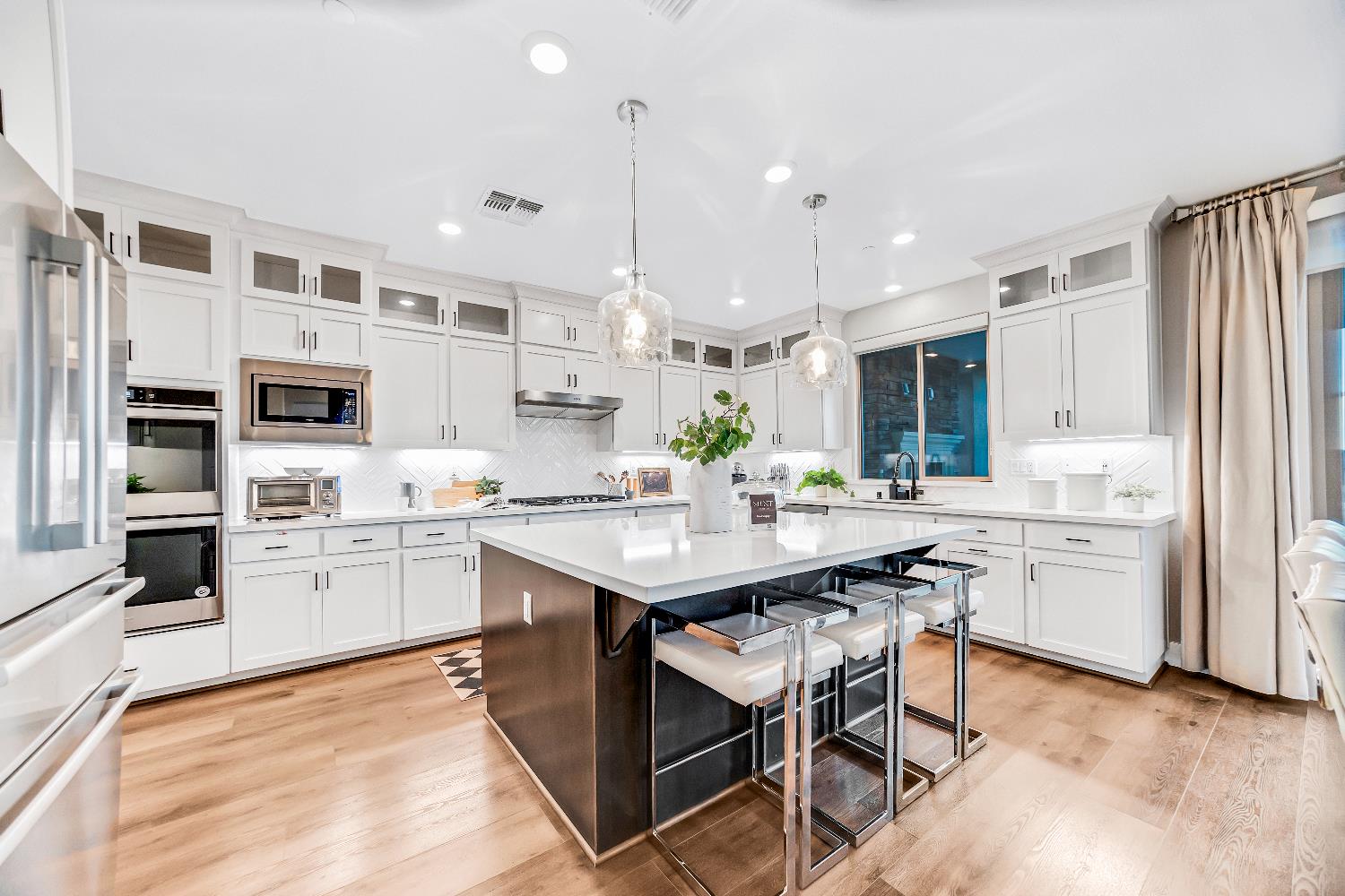 2947 Laredo Drive Rocklin, CA 95765 - Photo 6 of 65 a kitchen with stainless steel appliances kitchen island granite countertop a table chairs sink and cabinets