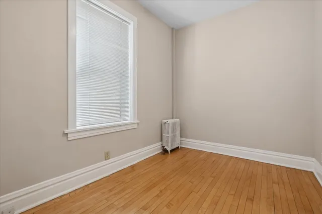 an empty room with a hardwood and a window