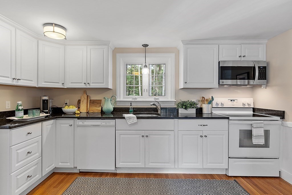 21 Oneida Road Acton, MA 01720 - Photo 7 of 39 a kitchen with granite countertop white cabinets white stainless steel appliances a sink and a window