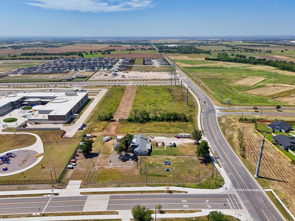Extensive land parcel featuring direct road frontage, surrounded by developed infrastructure, and adjacent to open fields