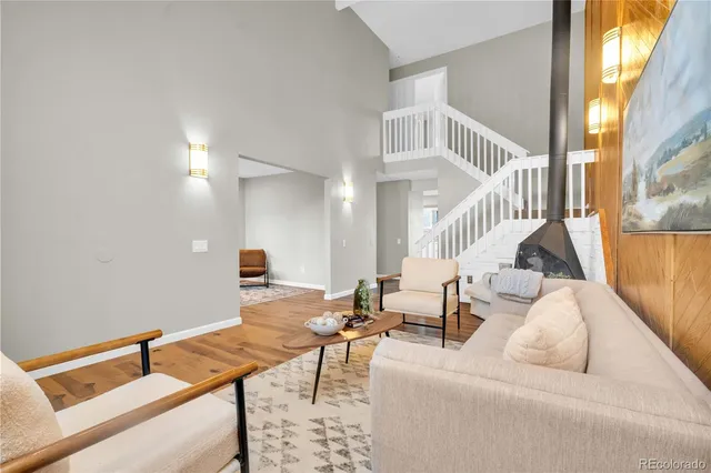 a living room with couches and a dining table with wooden floor