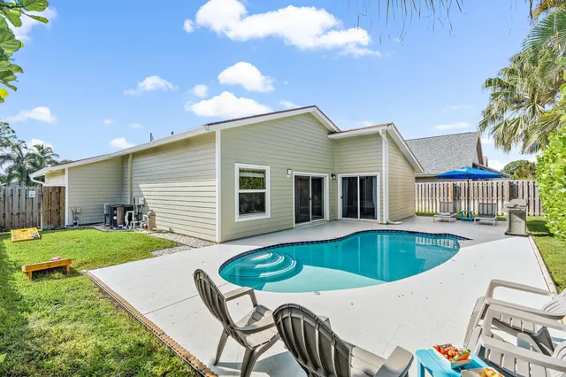 a view of a house with backyard and sitting area