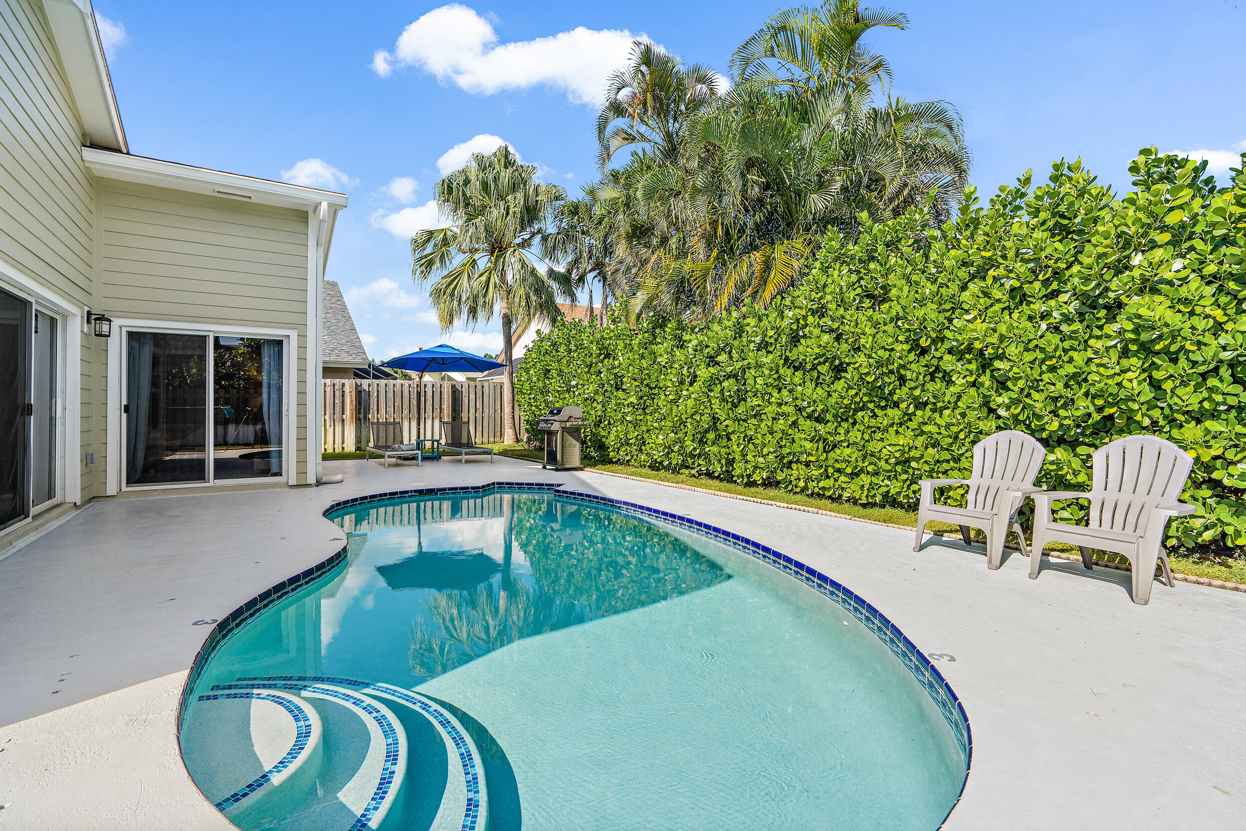6219 Linton Street Jupiter, FL 33458 - Photo 2 of 41 a view of a swimming pool with a lounge chair