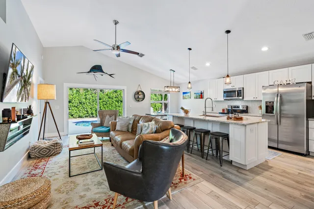 a living room with furniture kitchen and a large window