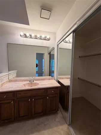 a spacious bathroom with a granite countertop sink and a mirror