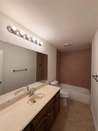 a bathroom with a tub sink and mirror