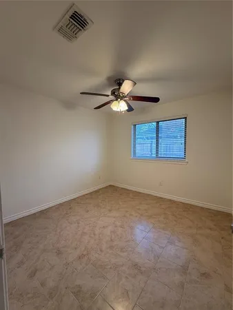 an empty room with windows and fan