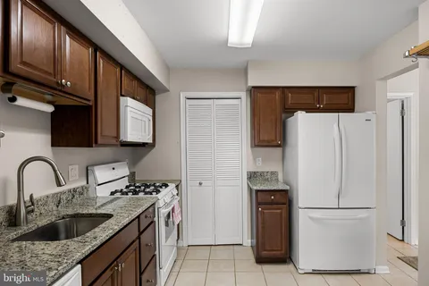 a kitchen with stainless steel appliances granite countertop a refrigerator sink and stove