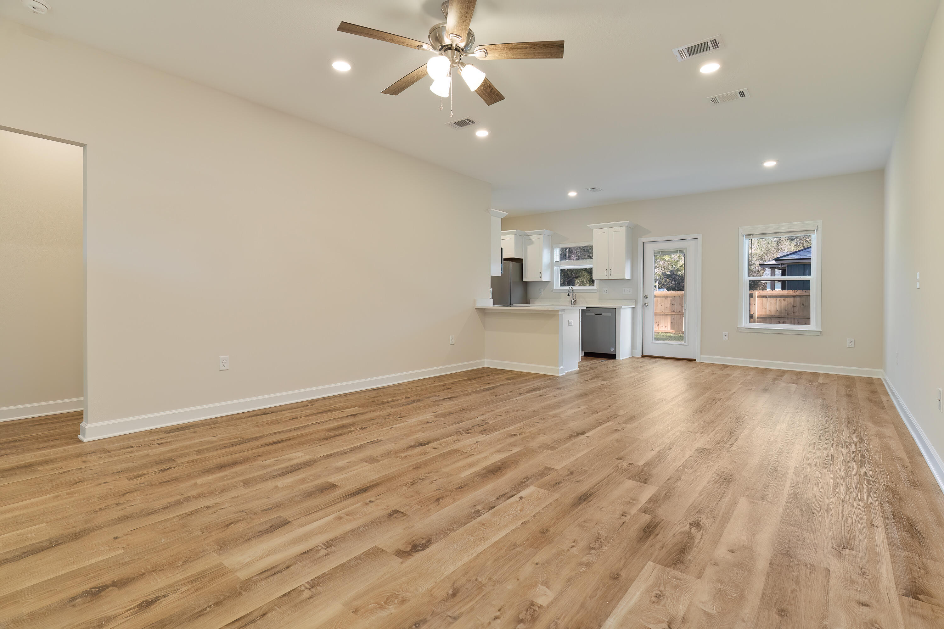 6194 Winstead Cove Crestview, FL 32539 - Photo 3 of 15 a view of a kitchen with a sink and dishwasher a refrigerator with wooden floor