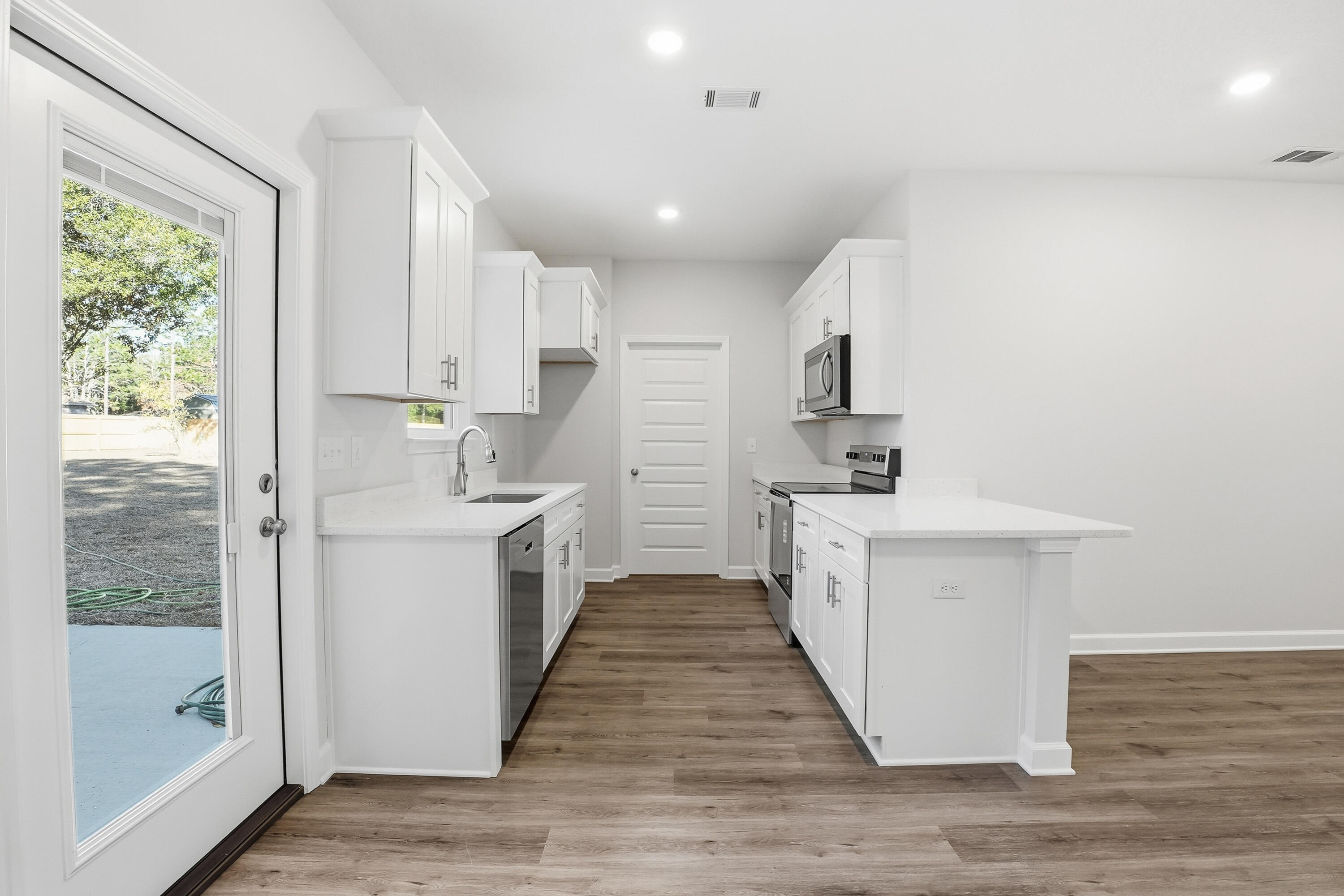 6194 Winstead Cove Crestview, FL 32539 - Photo 5 of 17 a kitchen with white cabinets and white appliances