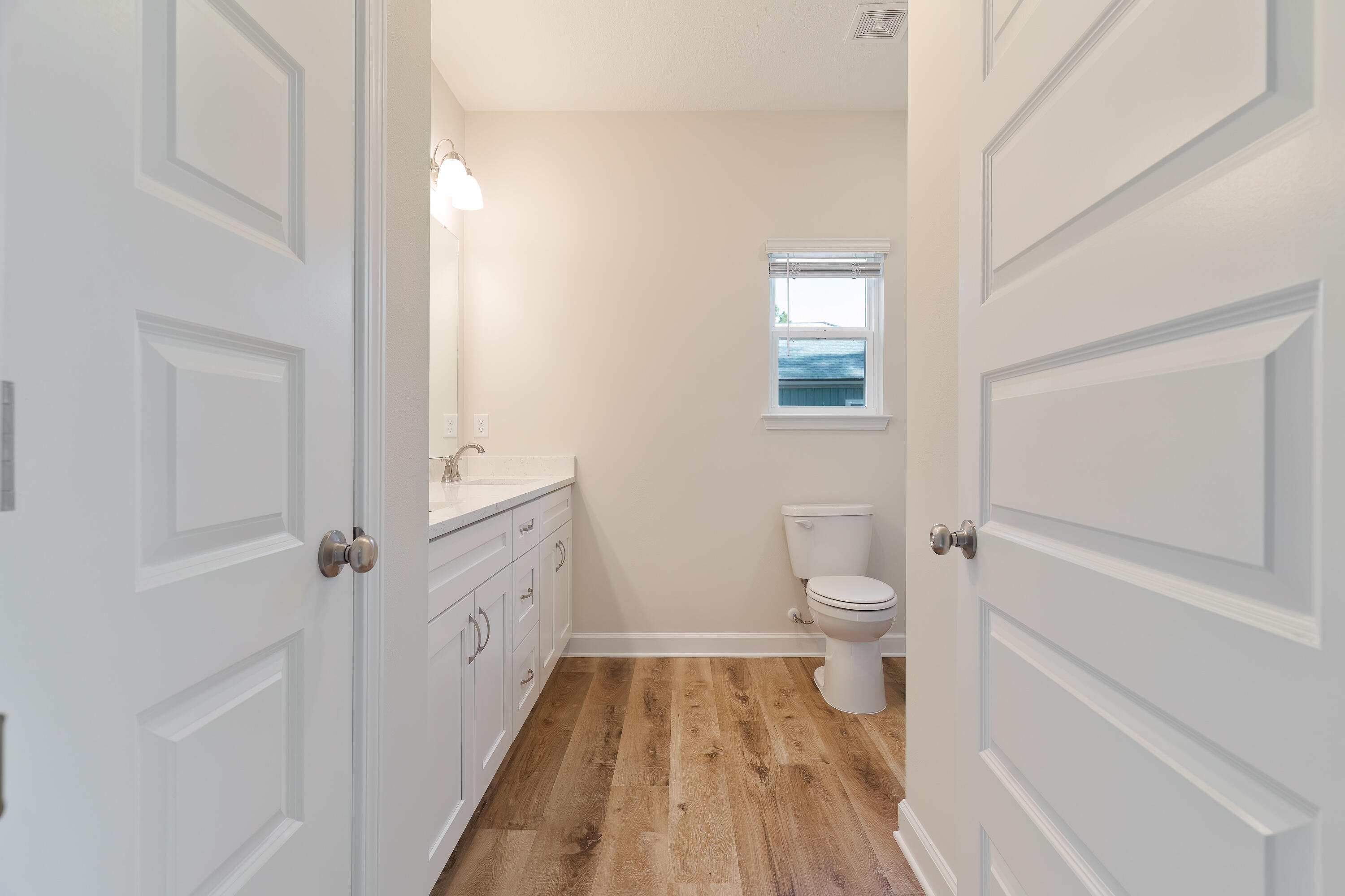 6194 Winstead Cove Crestview, FL 32539 - Photo 9 of 15 a bathroom with a granite countertop toilet a sink and a mirror