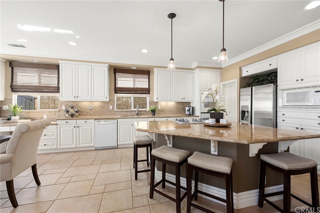 2442 Hawksfield Way Orange, CA 92867 - Photo 9 of 28 a kitchen with stainless steel appliances kitchen island granite countertop a sink a stove a refrigerator and cabinets