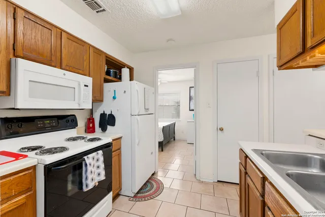 a kitchen with a stove a refrigerator and a sink