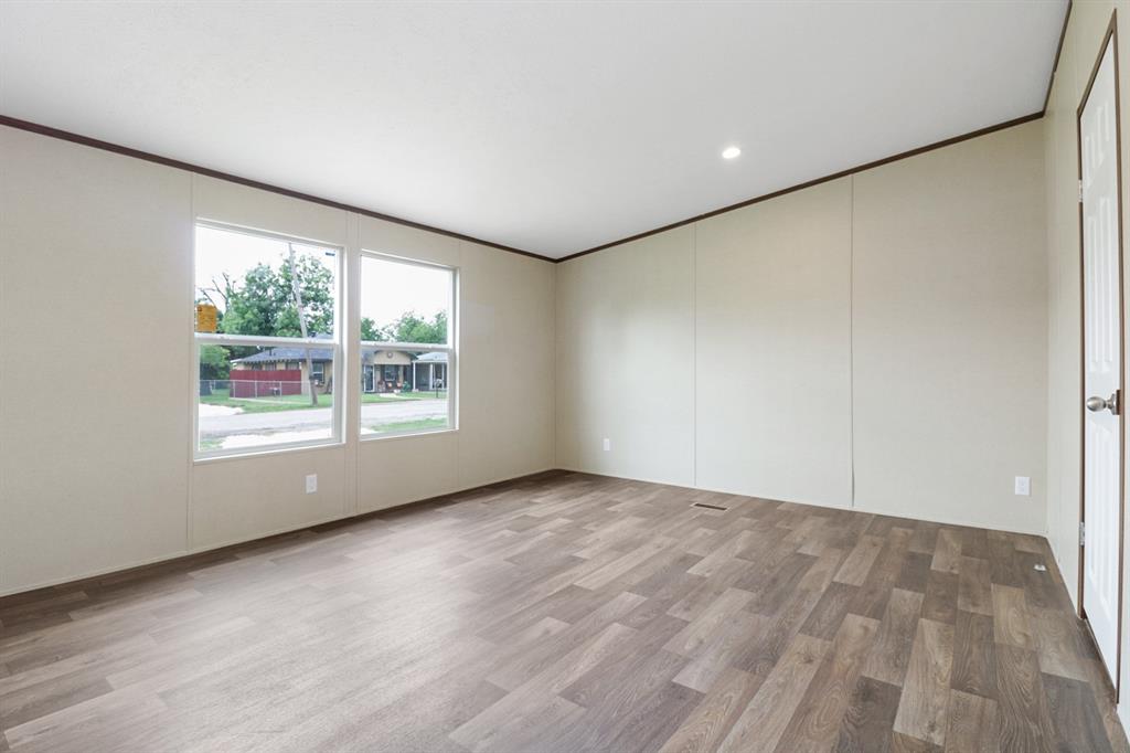 708 West 8th Street Coleman, TX 76834 - Photo 12 of 25 an empty room with wooden floor and windows