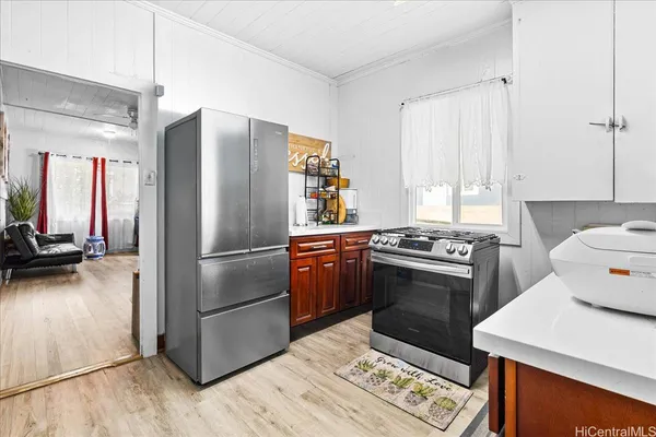 a kitchen with a stove a refrigerator and a wooden floor