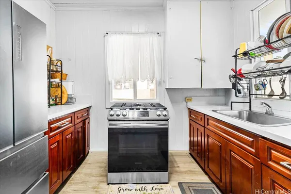 a kitchen with stainless steel appliances a sink stove and cabinets