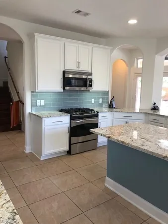 a kitchen with stainless steel appliances granite countertop a stove a sink and a microwave