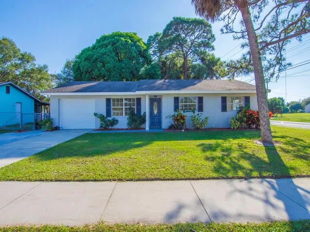 a kitchen with stainless steel appliances granite countertop a sink a stove and a refrigerator with wooden floor