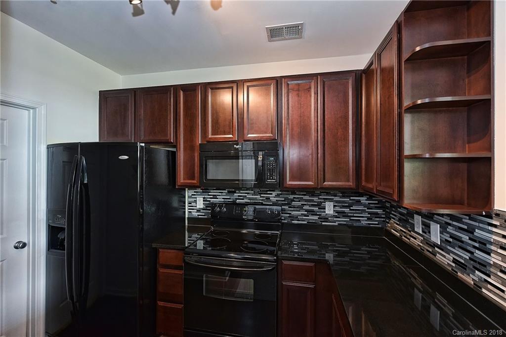 609 Raphael Place Charlotte, NC 28205 - Photo 17 of 36 a kitchen with a refrigerator and a stove top oven