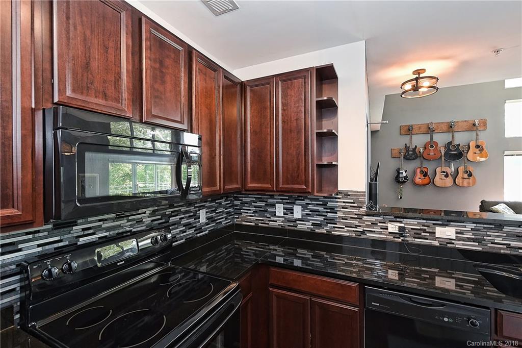 609 Raphael Place Charlotte, NC 28205 - Photo 18 of 36 a kitchen with wooden cabinets and a stove top oven