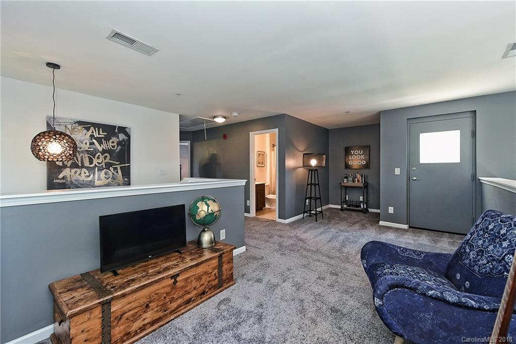 609 Raphael Place Charlotte, NC 28205 - Photo 29 of 36 a living room with furniture a flat screen tv and a fireplace