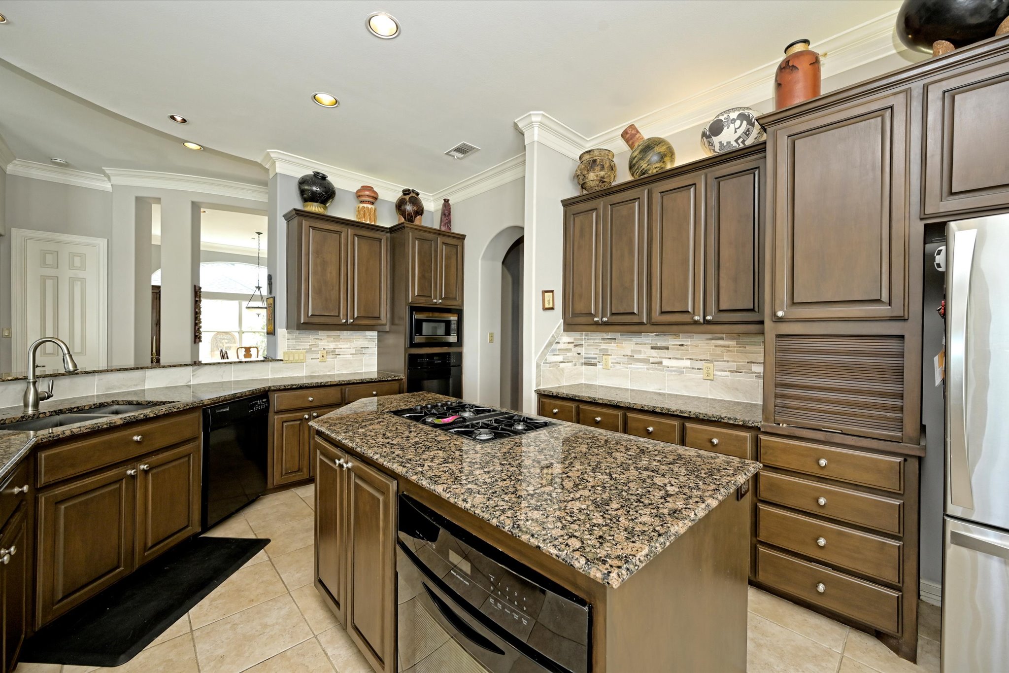 4912 Interlachen Lane Austin, TX 78747 - Photo 9 of 39 a kitchen with kitchen island granite countertop a sink stove and cabinets