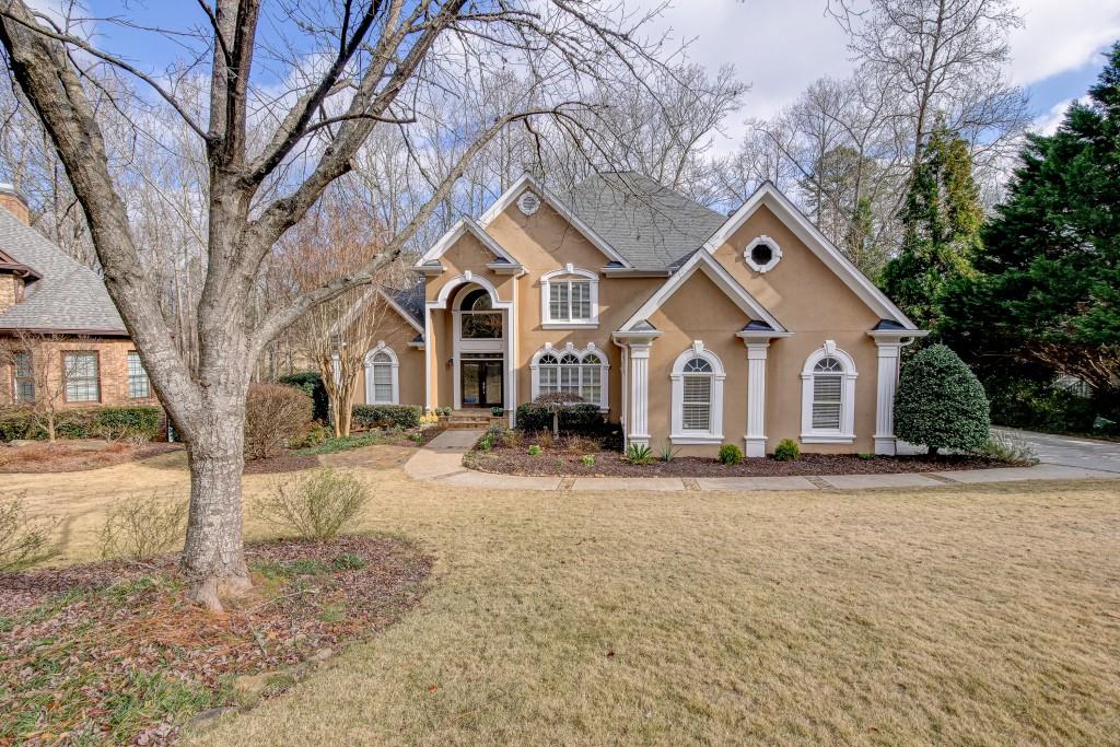 a front view of a house with a yard covered in snow