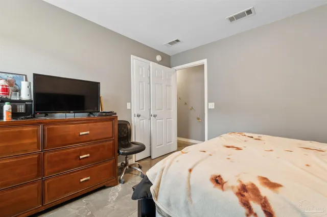 a bedroom with a bed and a flat screen tv