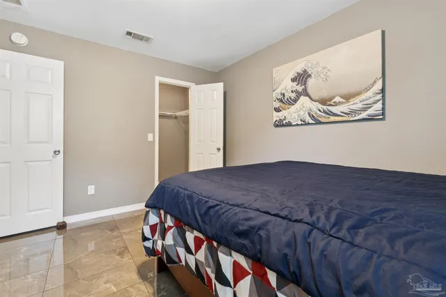 a bedroom with a bed and a painting on the wall