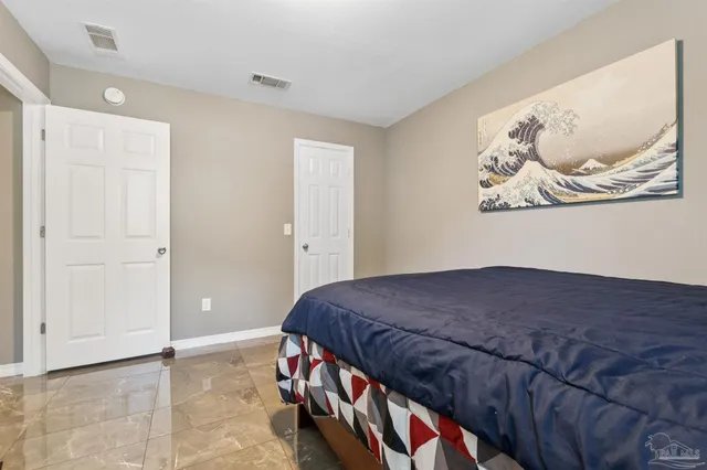 a bedroom with a bed and painting on the wall