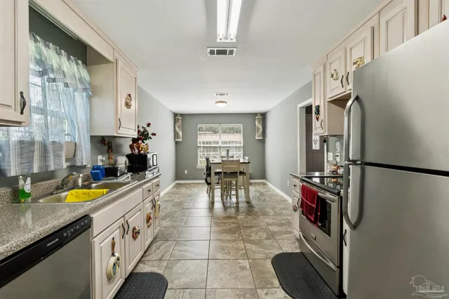 a view of a kitchen with furniture and a refrigerator