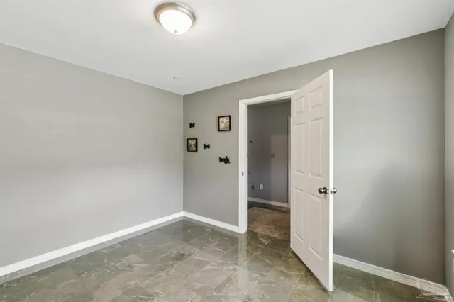 an empty room with a bench and a sink