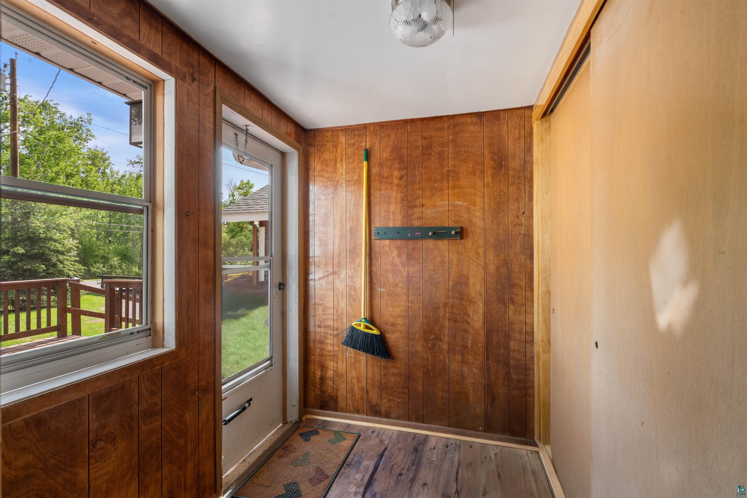 4793 Anderson Road Hermantown, MN 55811 - Photo 24 of 39 Wood-paneled room featuring a window and glass-paneled door