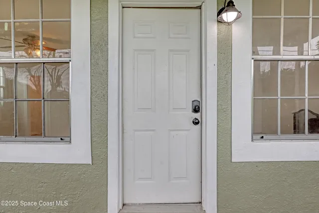 a view of an empty room with a fireplace and a chandelier fan