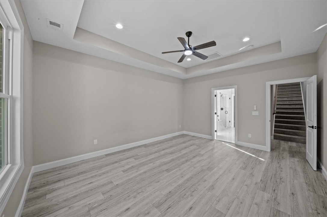 105 Bree Drive Anderson, SC 29621 - Photo 19 of 48 A spacious room features a tray ceiling, recessed lighting, and stylish plank flooring.