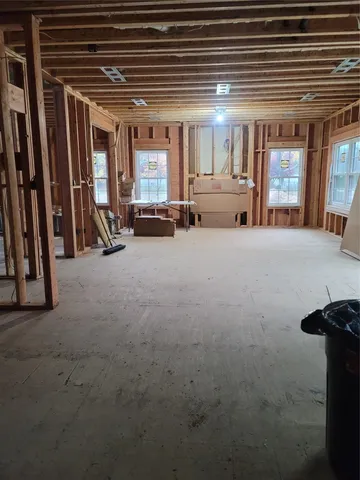 an empty room with chair and windows